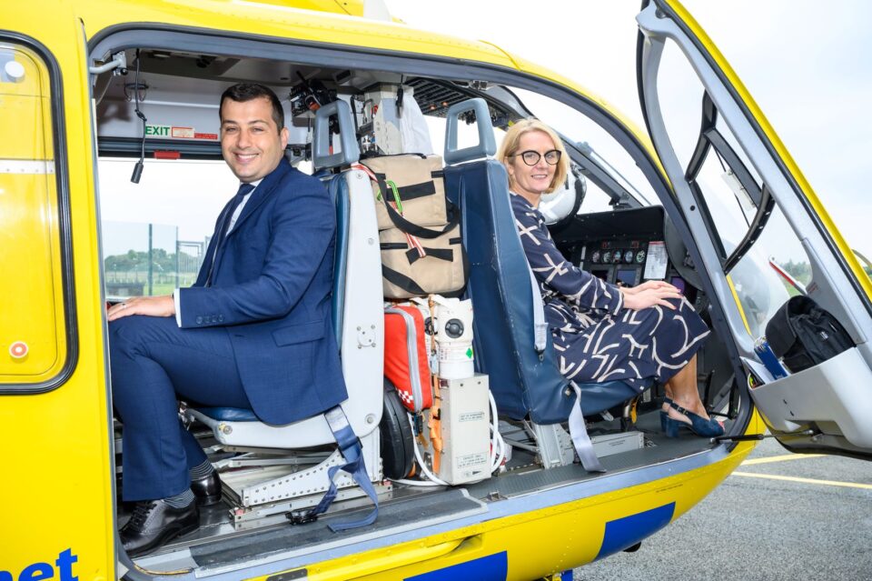 image of two people sat in a helicopter smiling