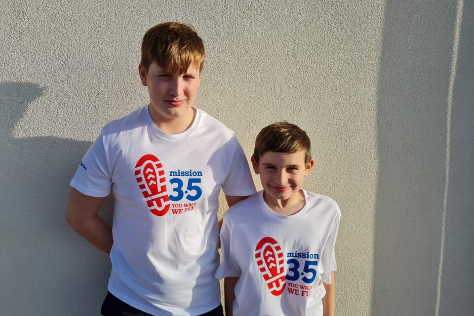 Olly and Seb wear t-shirts with Mission 3.5 logo - a red footprint