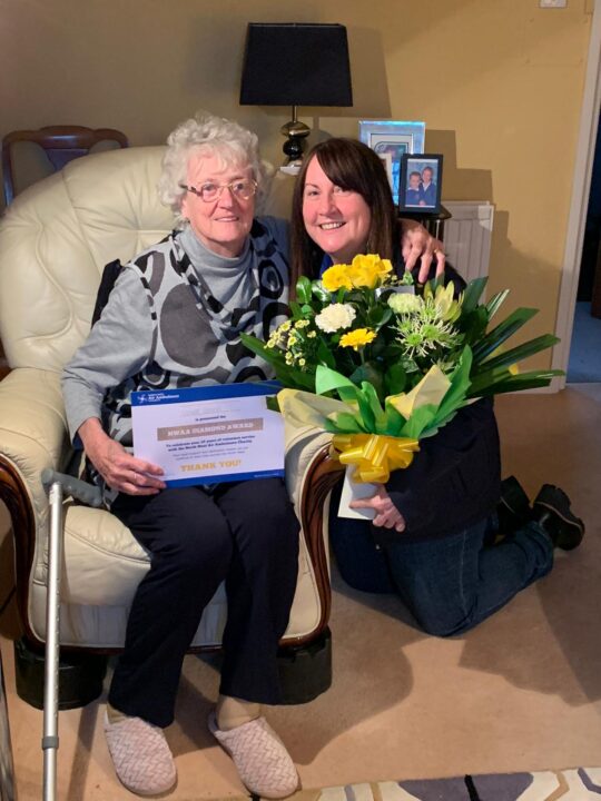 Violet Leach is presented with a certificate and flowers by volunteer coordinator Lisa Rawcliffe