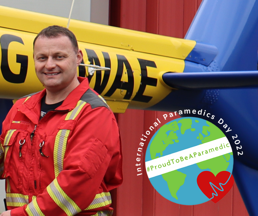 Image of Critical Care Paramedic Lee by the NWAA helicopter in his flight suit