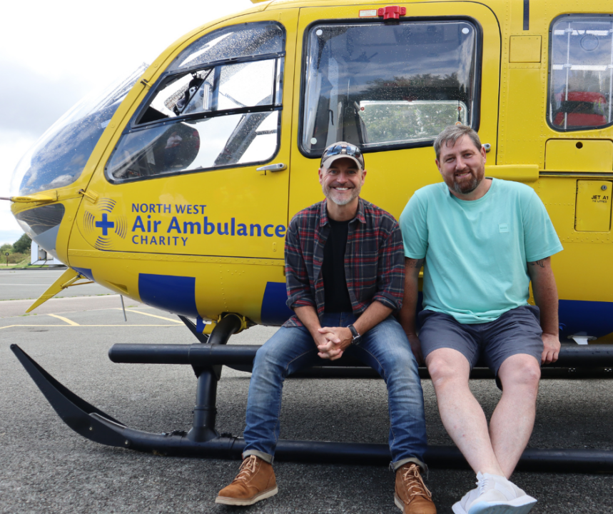 Robert and Chris sat in front of a NWAA helicopter