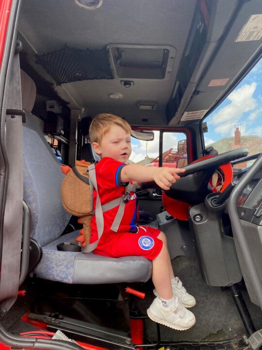 Henry pretending to drive a fire truck 