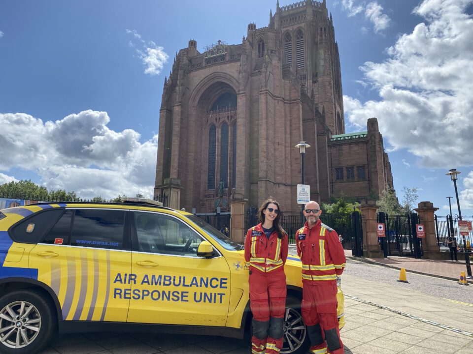 Crew members in flight suits, in front Liverpool Anglican Cathedral.