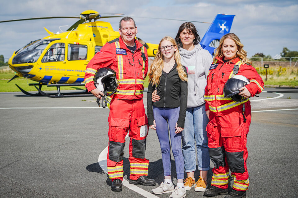 Ruby, her mum Sinead, Doctor Eimhear and Critical Care Paramedic Andy stood in front of the charity's helicopters