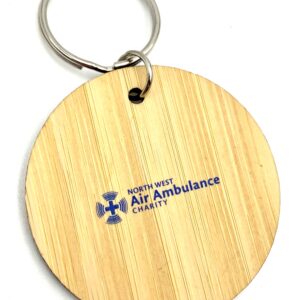 Light wood circle on a metal keyring with the North West Air Ambulance blue logo in the centre.