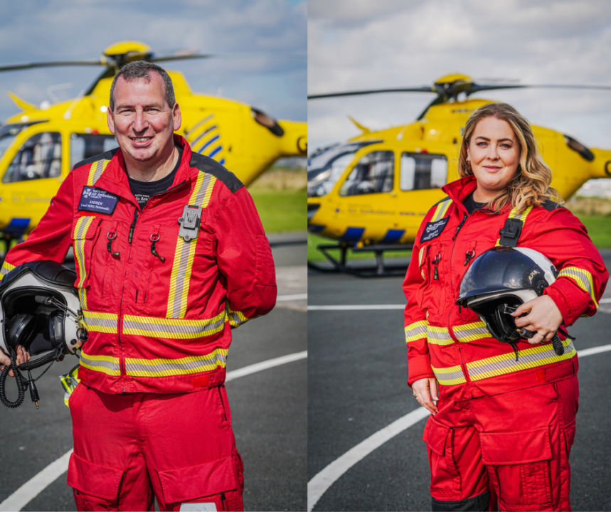 Andy on the left in his red flight suit in front of the helicopter, Eimhear on the right in her red flight suit in front of the helicopter