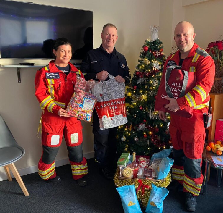 Th crew at Blackpool stood holding the foodie treats donated to NWAA