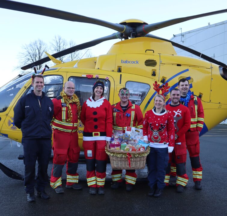 The crew at the Barton Airbase stood in front of the helicopter wearing Christmas jumpers 