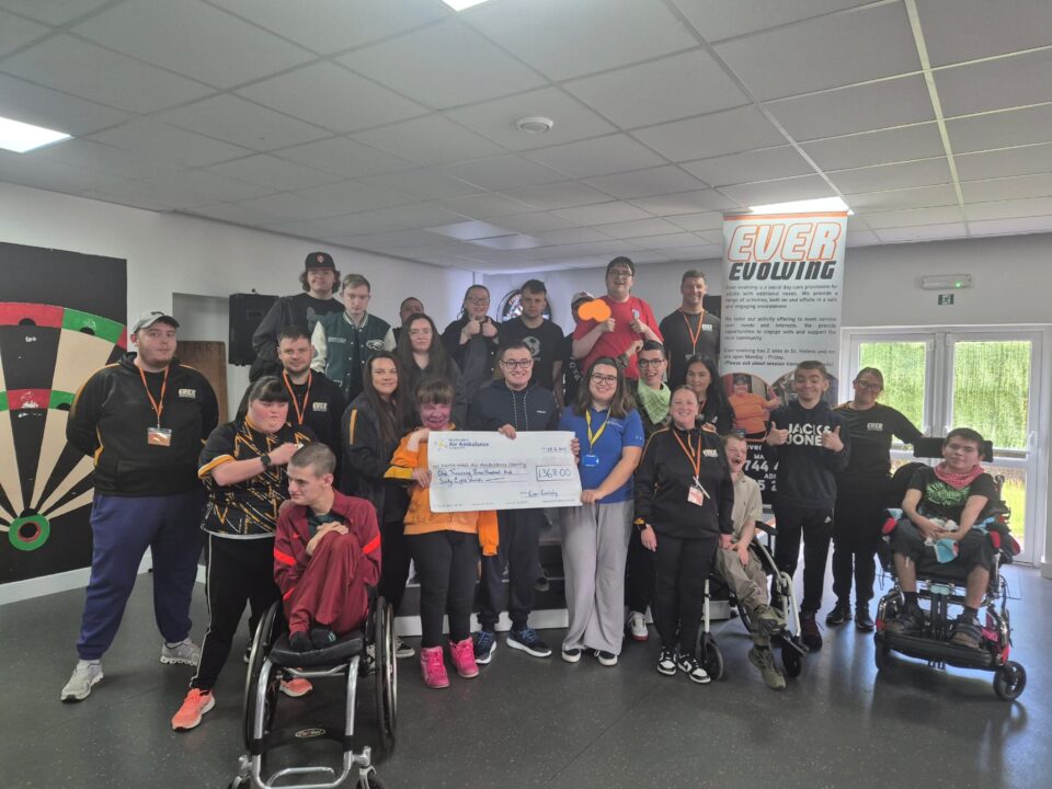 Group of fundraisers stood with one of the NWAA events team holding a cheque with the total amount of their fundraising 